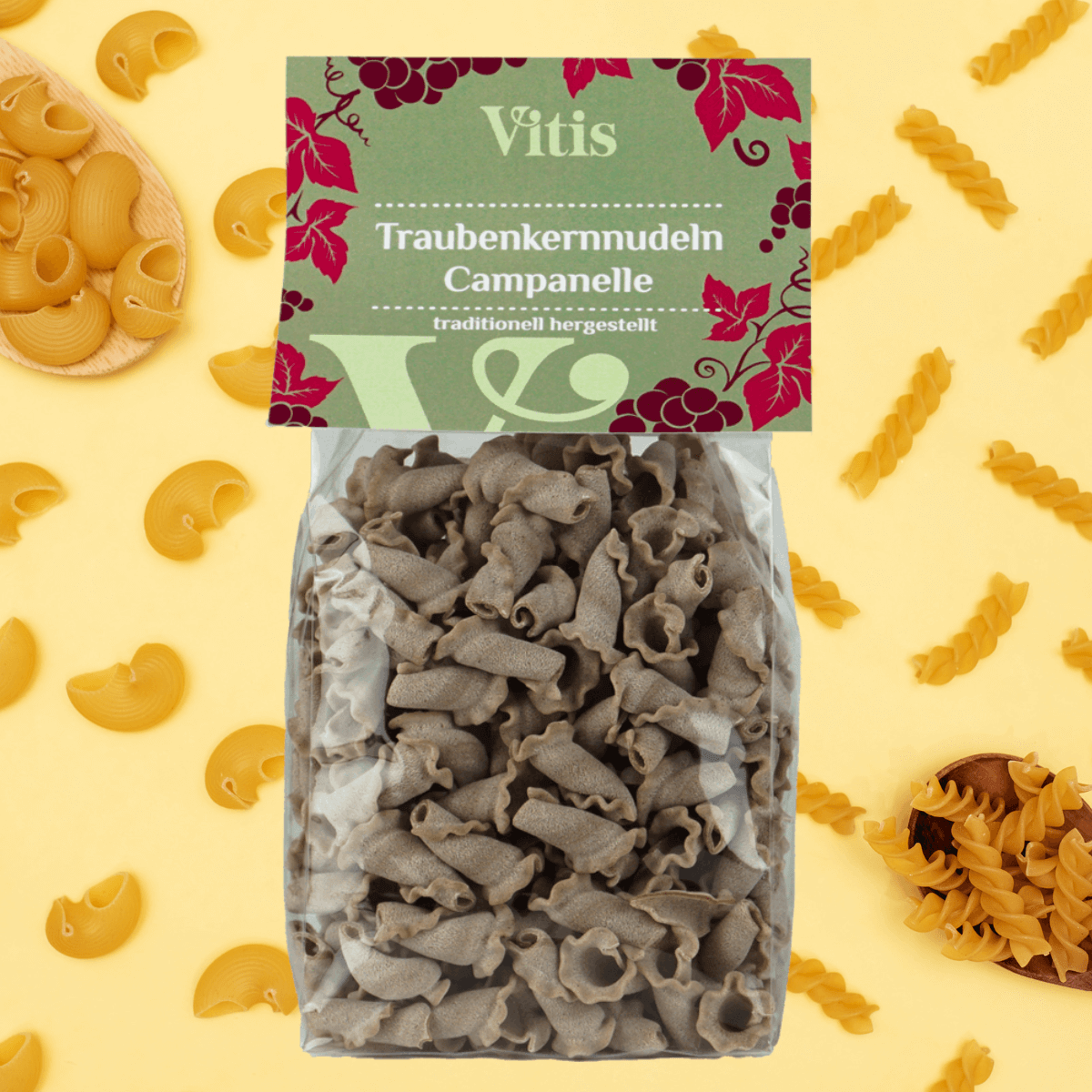 Eine Packung Traubenkernnudeln Campanelle von Vitis auf dekorativem Hintergrund.
