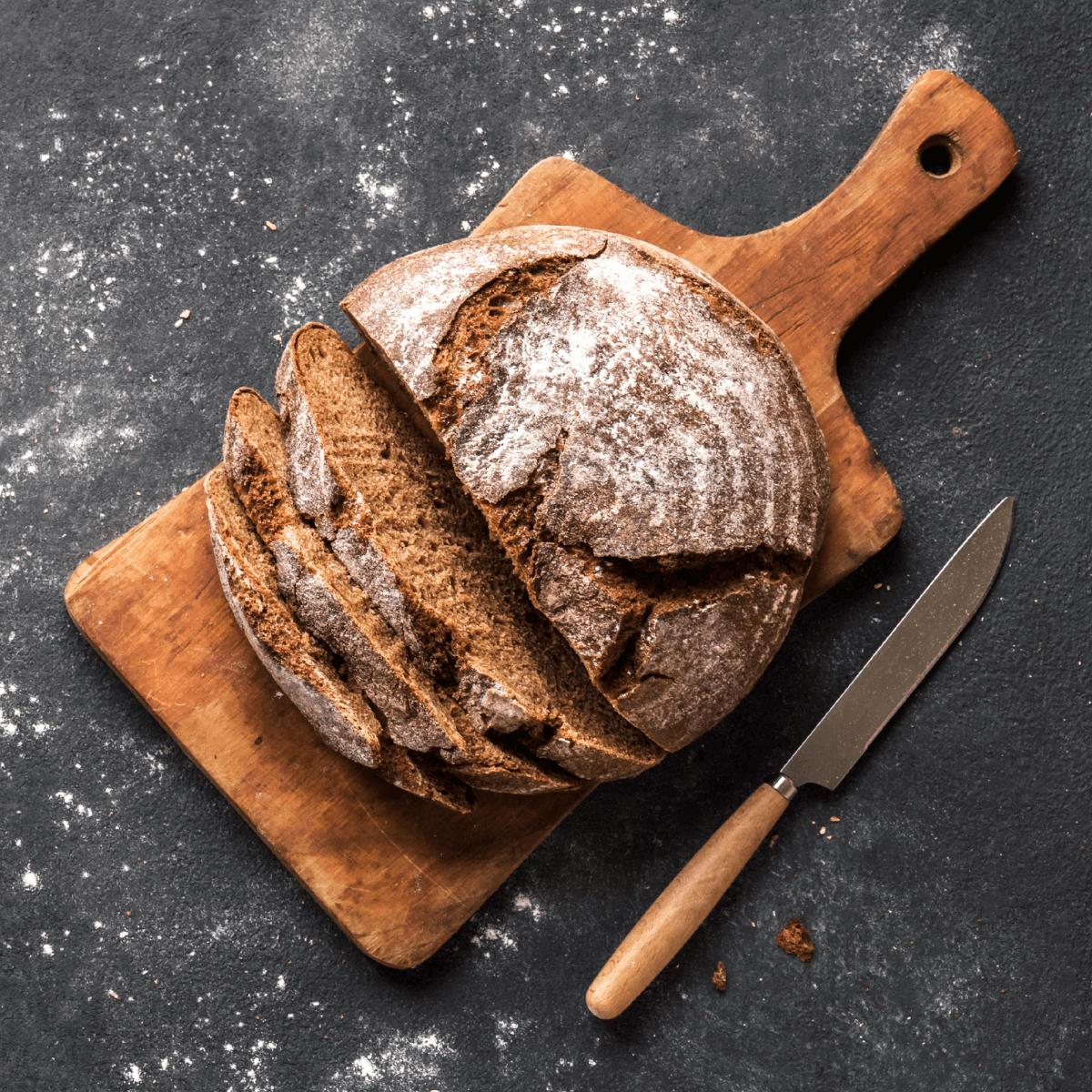 Ein frisch gebackenes Brot auf einem Holzbrett in Nahaufnahme.