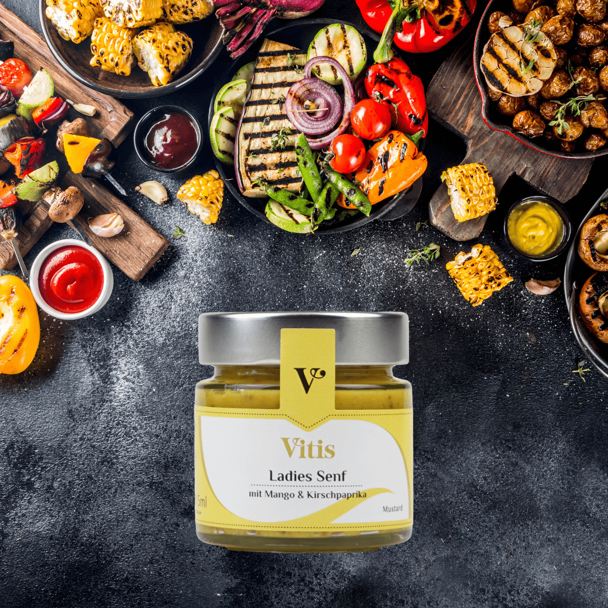 Ein Glas Ladies Senf von Vitis auf dunklem Hintergrund. Im oberen Teil des Bildes sind verschiedene Grillgerichte zu sehen.