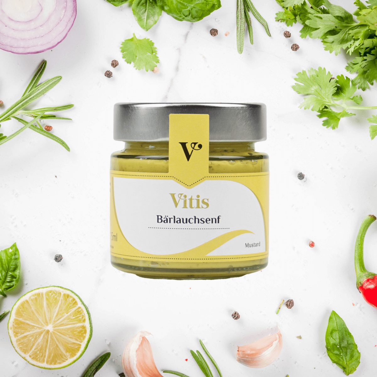 Ein Glas Bärlauchsenf von Vitis auf hellem Hintergrund. Um das las herum liegen verschiedene Kräuter als Dekoration.