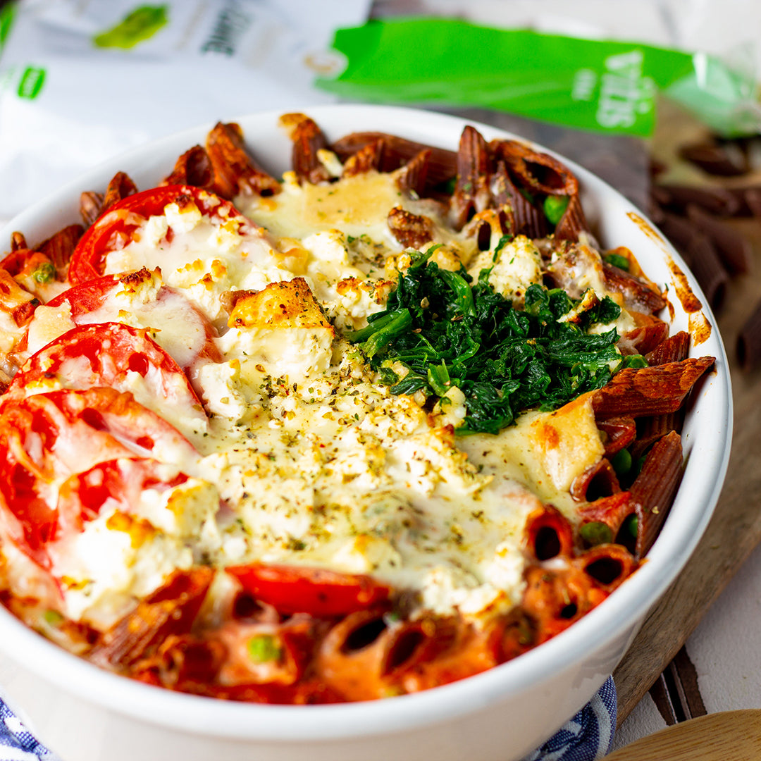 Eine weiße Schale mit einem Auflauf von Traubenkernnudeln mit Frischkäse.