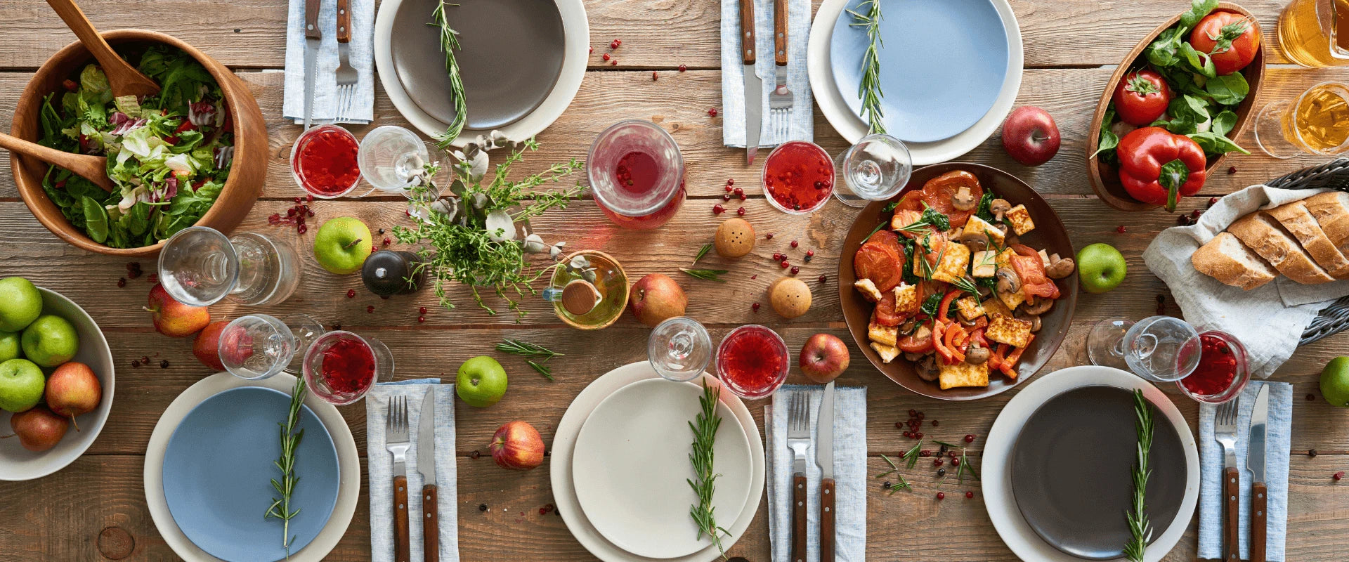 Ein gedeckter Tisch von oben. Es stehen Salate, Bot und verschiedene gekochte Gerichte auf dem Tisch.