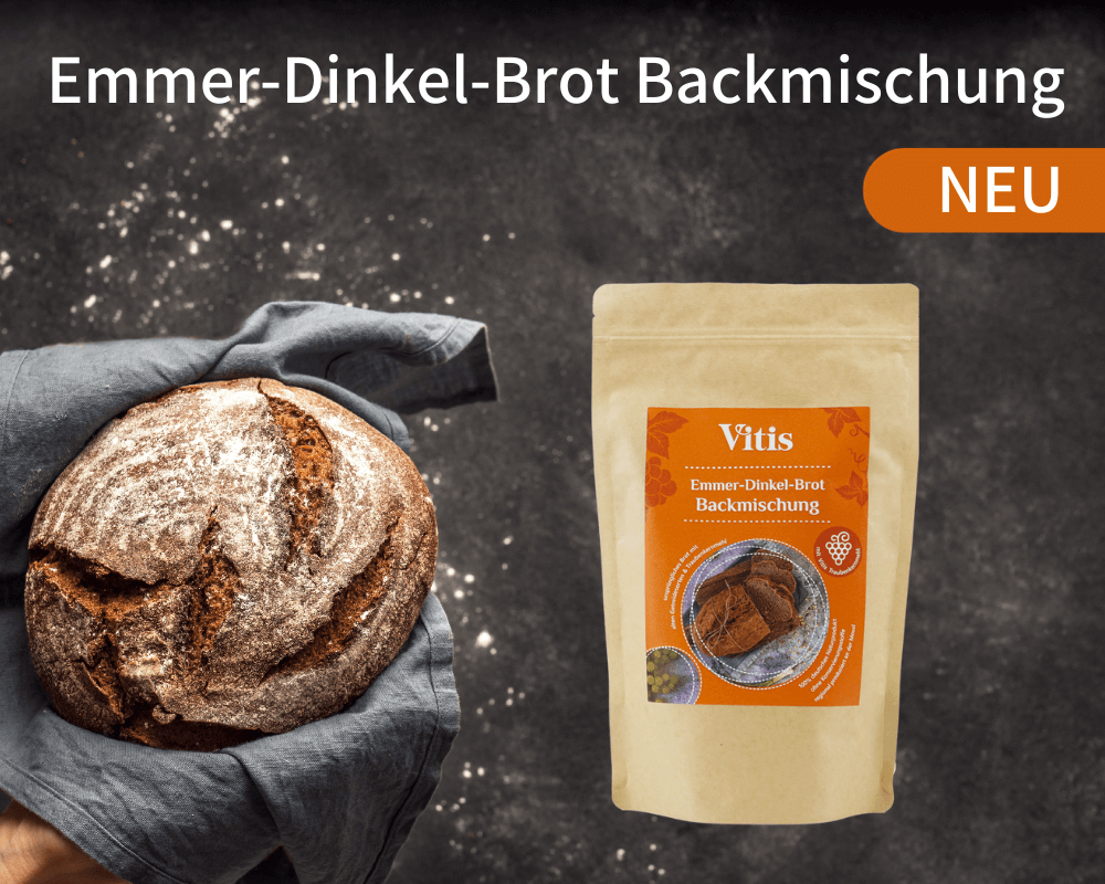 Eine 500g Emmer-Dinkel-Brot Backmischung von Vitis neben einen frisch gebackenen Brot.
