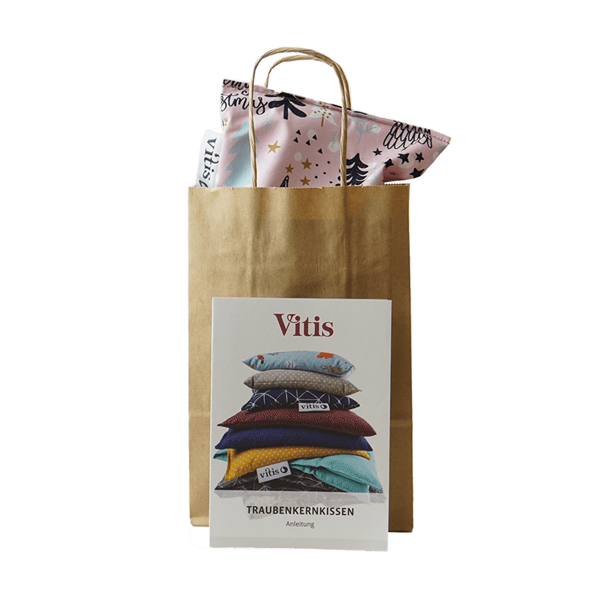 Eine Papiertüte mit einem kleinen weihnachtlichen Traubenkernkissen von Vitis24 mit einer Anleitung zur Nutzung des Traubenkernkissens im Vordergrund.